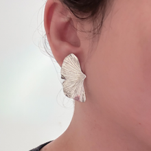 Load image into Gallery viewer, Close-up of a silver leaf-shaped earring on an ear against a neutral background