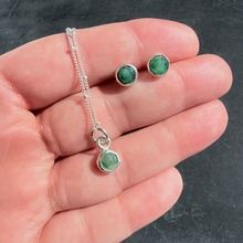 Load image into Gallery viewer, Silver jewelry set with green gemstones held in a hand against a dark background
