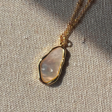 Load image into Gallery viewer, Gold-plated organic shell pendant necklace on a linen background
