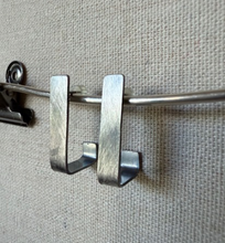 Load image into Gallery viewer, Metal U-shaped bracket on a gray fabric background
