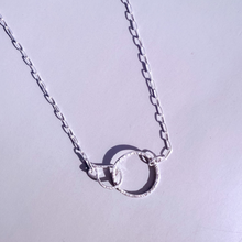 Load image into Gallery viewer, A sterling silver necklace with two interlocking hoops on an adjustable chain, displayed against a light background.
