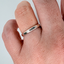 Load image into Gallery viewer, Hand wearing a silver ring on a plain background
