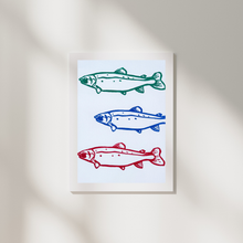 Load image into Gallery viewer, Framed artwork with three stylized fish illustrations in green, blue, and red on a light background.

