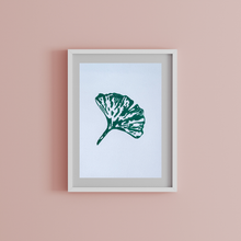 Load image into Gallery viewer, Framed artwork of a green leaf on a pink wall
